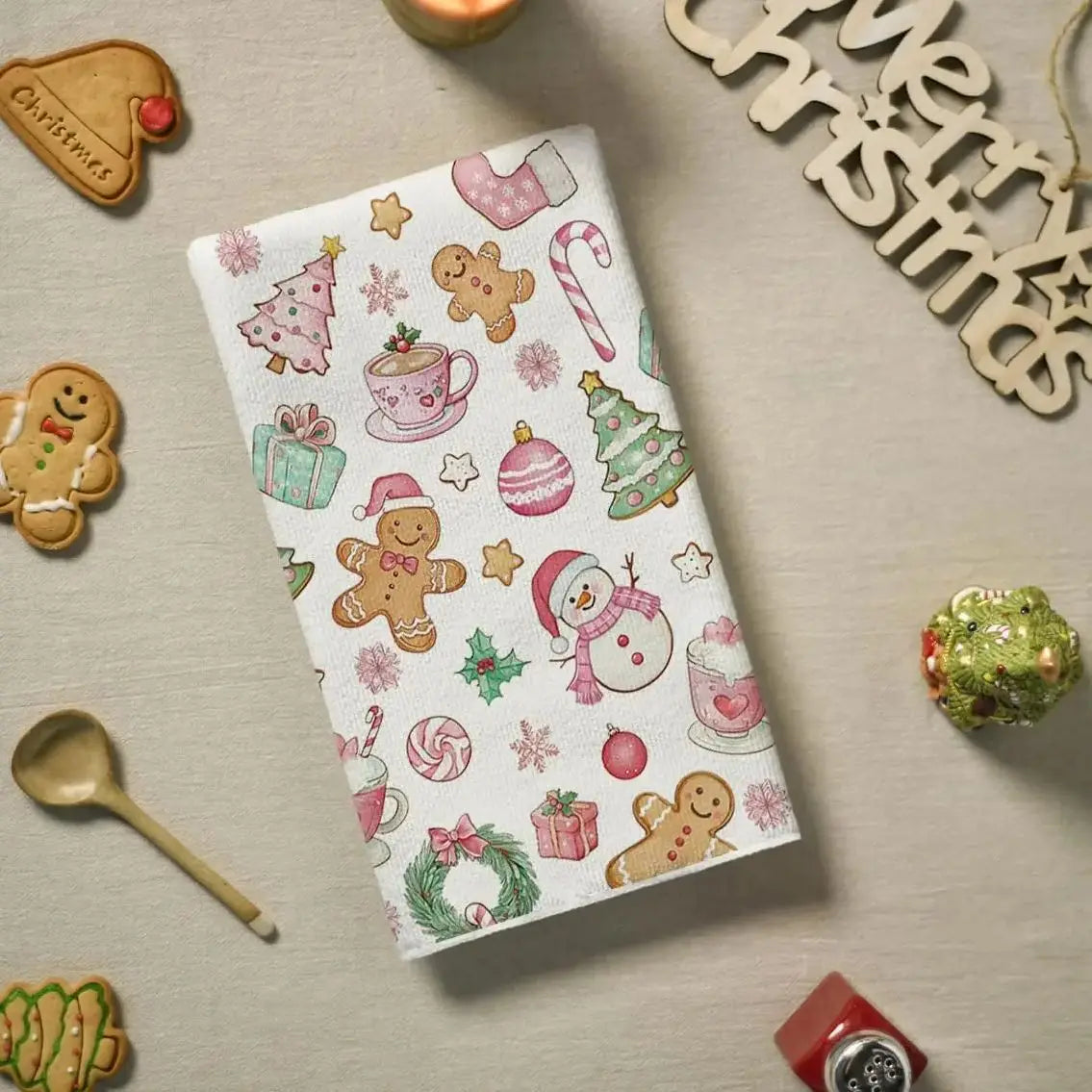 A set of two festive pink snowman Christmas kitchen towels decorated with holiday patterns and stars.