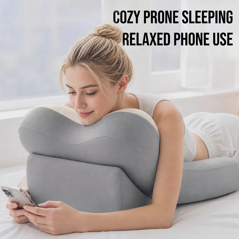 A woman is using an ergonomic memory foam lumbar pillow while relaxing and using her phone.