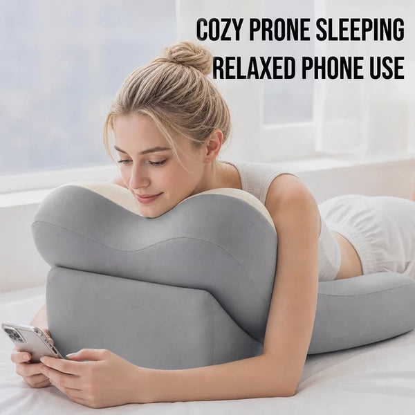 A woman is using an ergonomic memory foam lumbar pillow while relaxing and using her phone.
