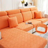 Orange jacquard plush sofa cushion cover with textured fabric and decorative pillows on a white sofa.