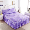 Purple double layer printed bed skirt with floral pattern on a white wooden bed frame.
