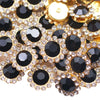 Close-up of gold and black crystal rhinestone sew-on buttons arranged in a floral pattern.