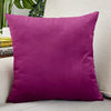 A square, deep magenta velvet cushion cover resting on a light-colored surface.