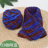 A rolled piece of blue and brown chenille knitting yarn resting on a woven mat.