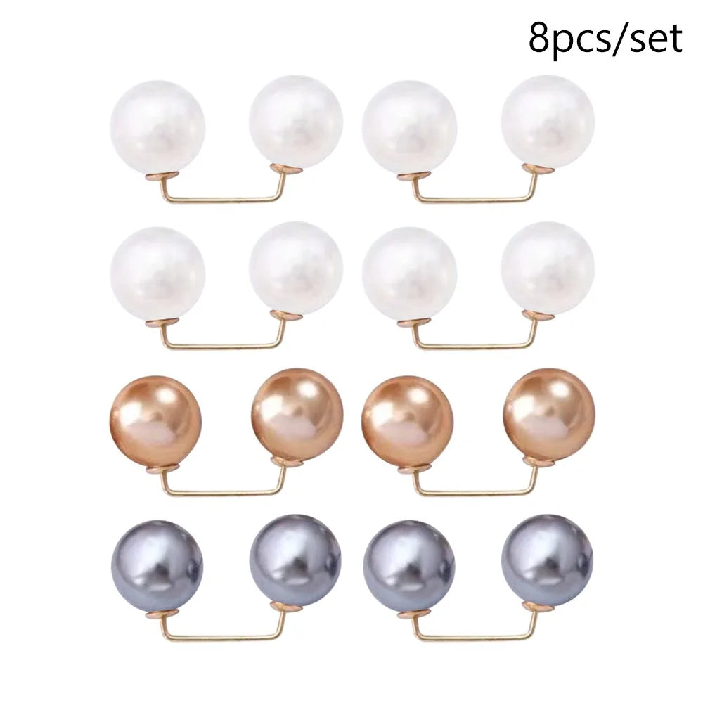 A set of eight pearl-colored stud earrings with gold-toned findings.