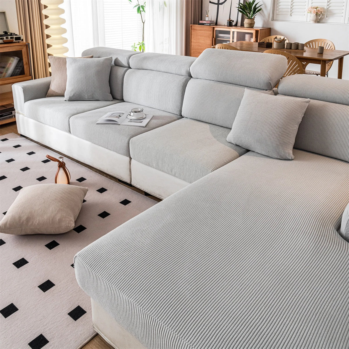A light gray removable jacquard seat cushion cover on a modular sofa in a bright living room setting.