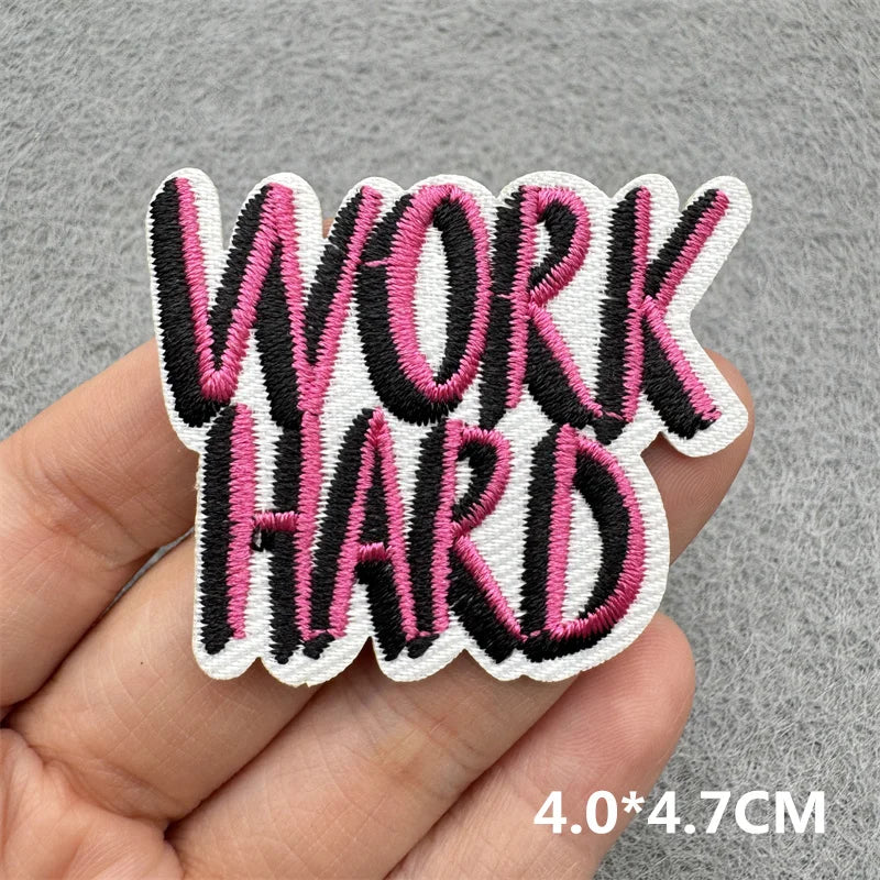 Black and pink embroidered patch with the text WORK HARD