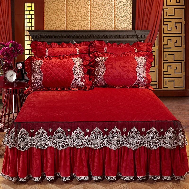 A vibrant red bed skirt set featuring a ruffled hem and lace trim, displayed on a richly decorated bed.