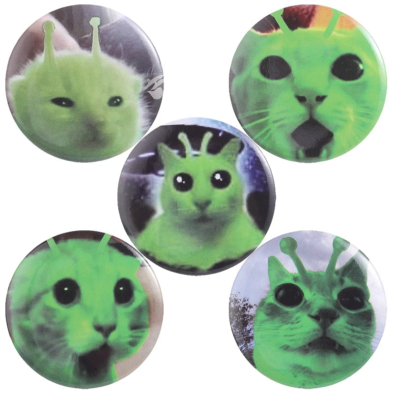 A set of five tinplate pin brooches featuring green, stylized animal faces.