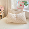 A set of white microfiber duvet cover and pillowcases with small black polka dots on a bed.