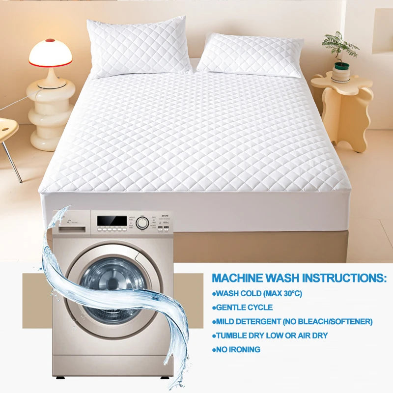 A white quilted mattress protector is shown next to a washing machine with wash instructions.