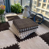 A plush interlocking puzzle rug mat in brown and white squares is displayed on a light carpet.