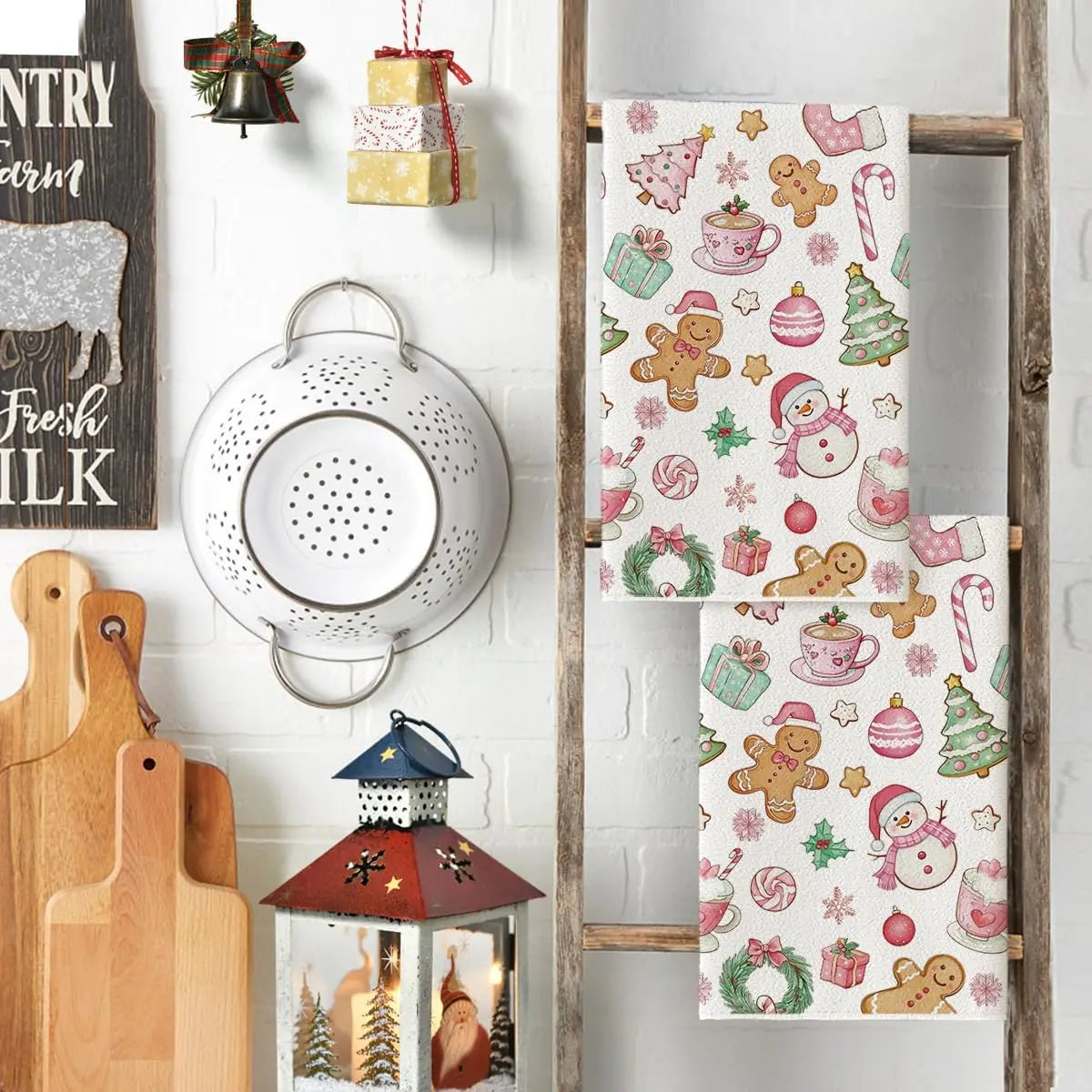 A set of two festive pink snowman Christmas kitchen towels featuring seasonal patterns like snowmen, ornaments, and greenery.