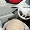Close-up view of a rotating car seat cushion in red and beige tones, showing its design and texture.