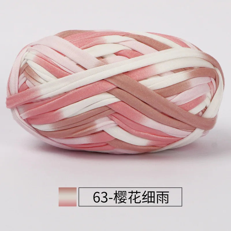 A ball of hand-dyed fabric strip yarn in pink and white stripes for crochet and knitting.
