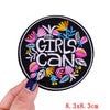 Black embroidered patch with the text Girls Can surrounded by colorful floral embroidery