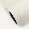 A close-up view of a thick, white, anti-slip decorative floor mat with a black trim.
