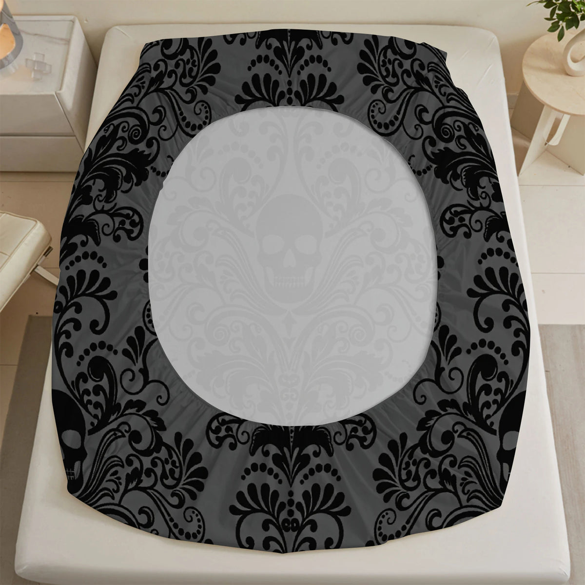 A black and gray floral skull pattern bed sheet set displayed on a white bed frame.