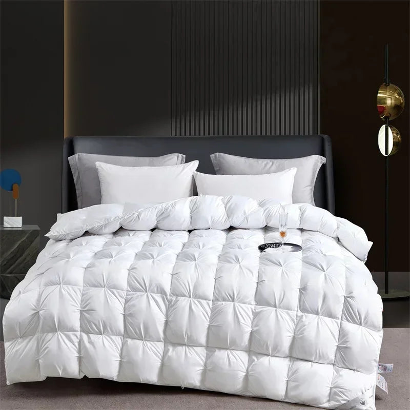A white quilted duvet with gray bedding is displayed on a bed against a dark wall.