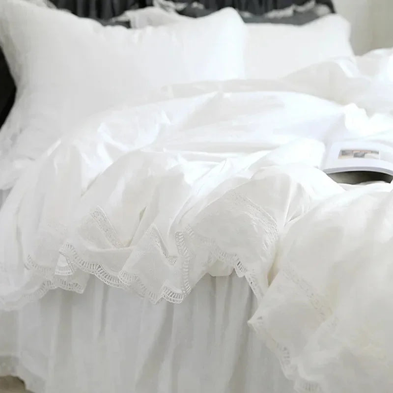 White luxury ruffle duvet cover displayed on a bed with white pillows and fabric.