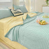 A light blue Korean style seersucker summer quilt set with yellow accents and white striped bedding.