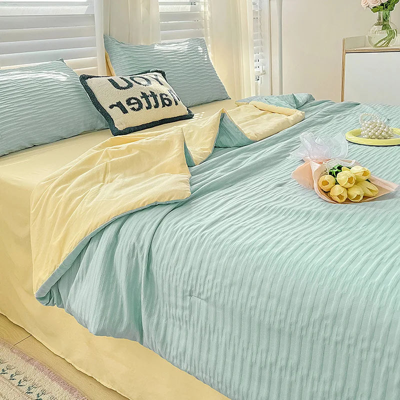 A light blue Korean style seersucker summer quilt set with yellow accents and white striped bedding.