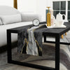 A black rectangular table runner with abstract gold and gray marble pattern on a dark wood table.