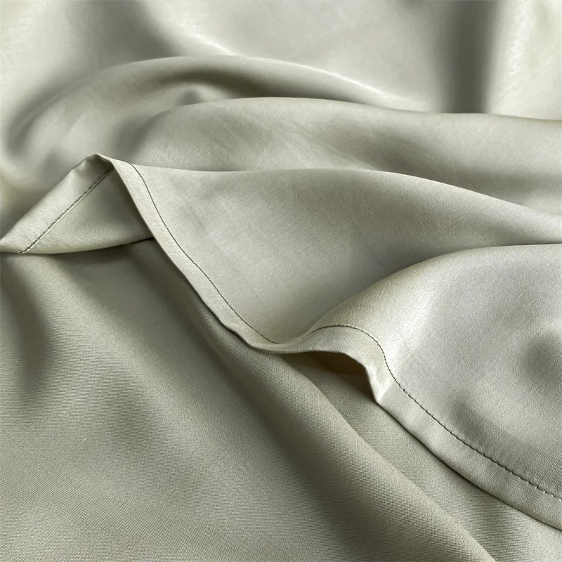 Soft, light beige bamboo flat sheets draped and folded to show fabric texture.