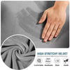Close-up of a hand touching a gray velvet fabric, showing the texture and softness of the material.