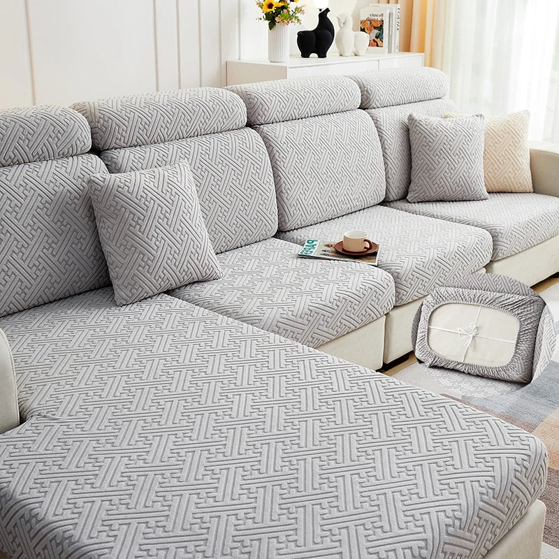 A gray jacquard plush sofa cushion cover featuring a geometric woven pattern on a sectional sofa.