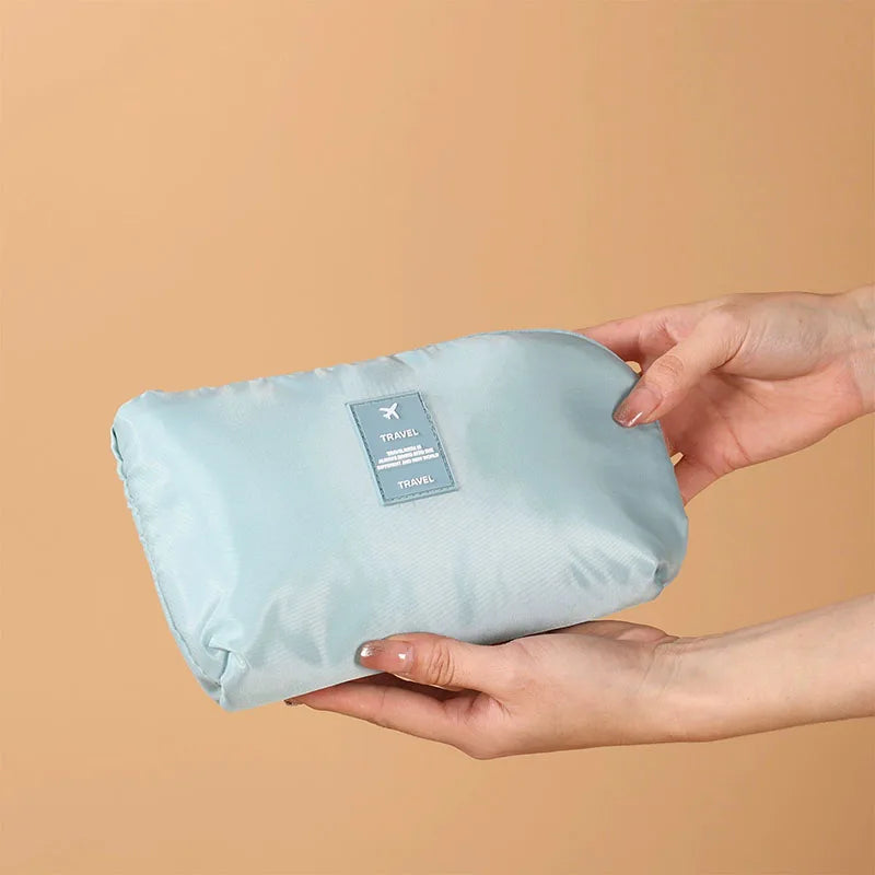 A hand holds a light blue mesh storage organizer set against a beige background.