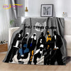 A black and white graphic blanket featuring silhouettes of martial arts figures with yellow accents.