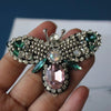 Handmade bee beaded sew-on patches featuring silver and green gemstones on a fabric background.