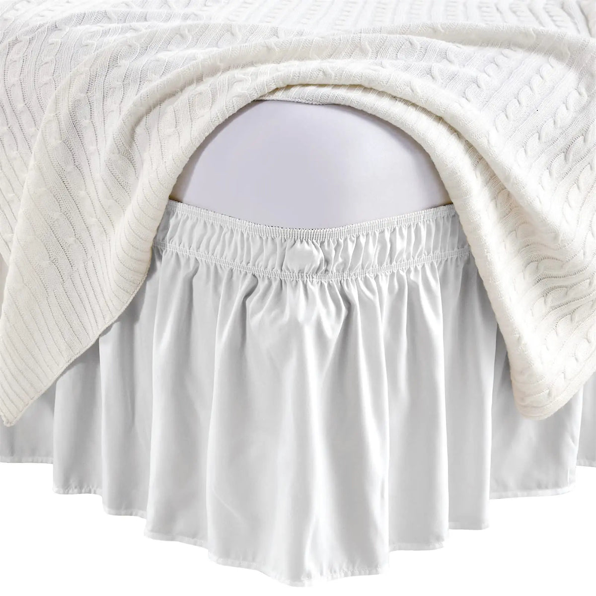 White elastic bed skirt with ruffles draped over a pregnant belly