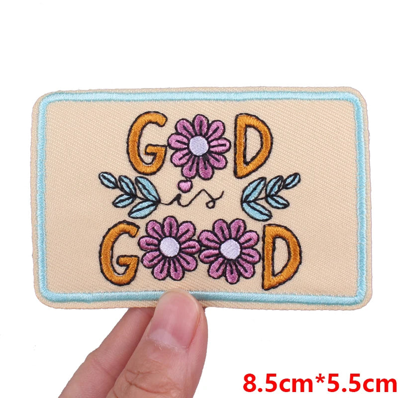 Light beige embroidered patch featuring the letters GOD surrounded by floral designs