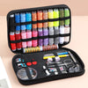 A black zippered pouch containing various colored threads and a complete sewing kit with tools like scissors and needles.