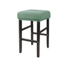 A green fabric bar stool slipcover with dark wooden legs and a textured seat.