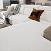 A white stretchy polar fleece sofa cover with a patterned throw and an accent pillow on a modern sofa.
