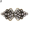 Vintage gold-toned swirl clip brooch featuring clear rhinestones and intricate metalwork