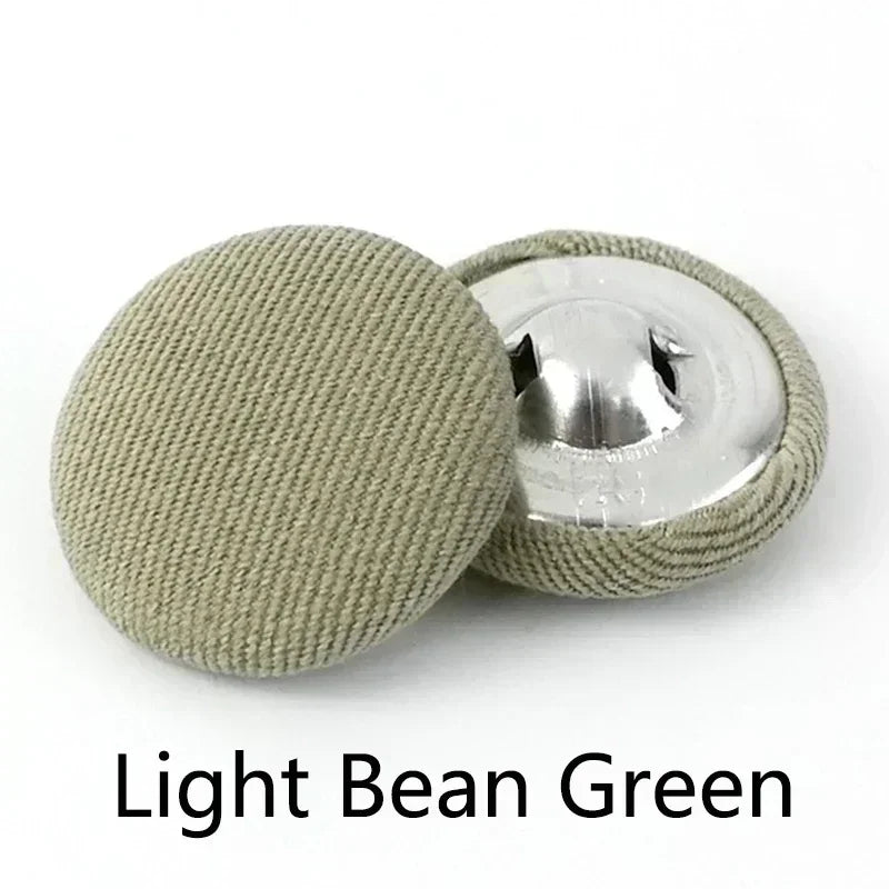 A set of light bean green round fabric-covered shank buttons for coats and jackets.