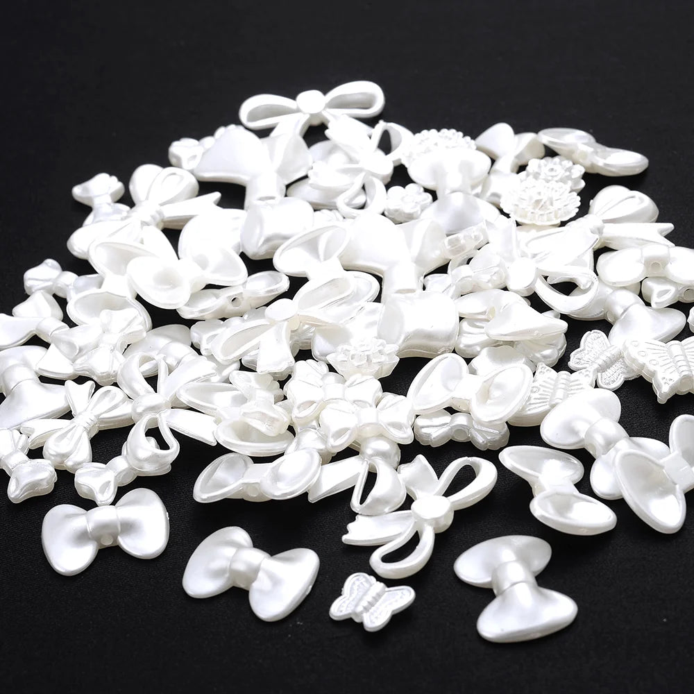 A pile of white imitation pearl flower spacer beads for DIY jewelry.