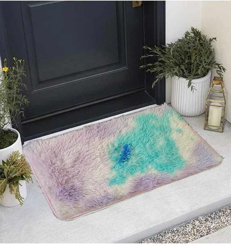 A thick silk wool area rug featuring a blend of purple and turquoise colors placed in front of a dark door.