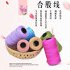 A collection of pink, purple, and green yarn spools for hand knitting and crochet crafting.