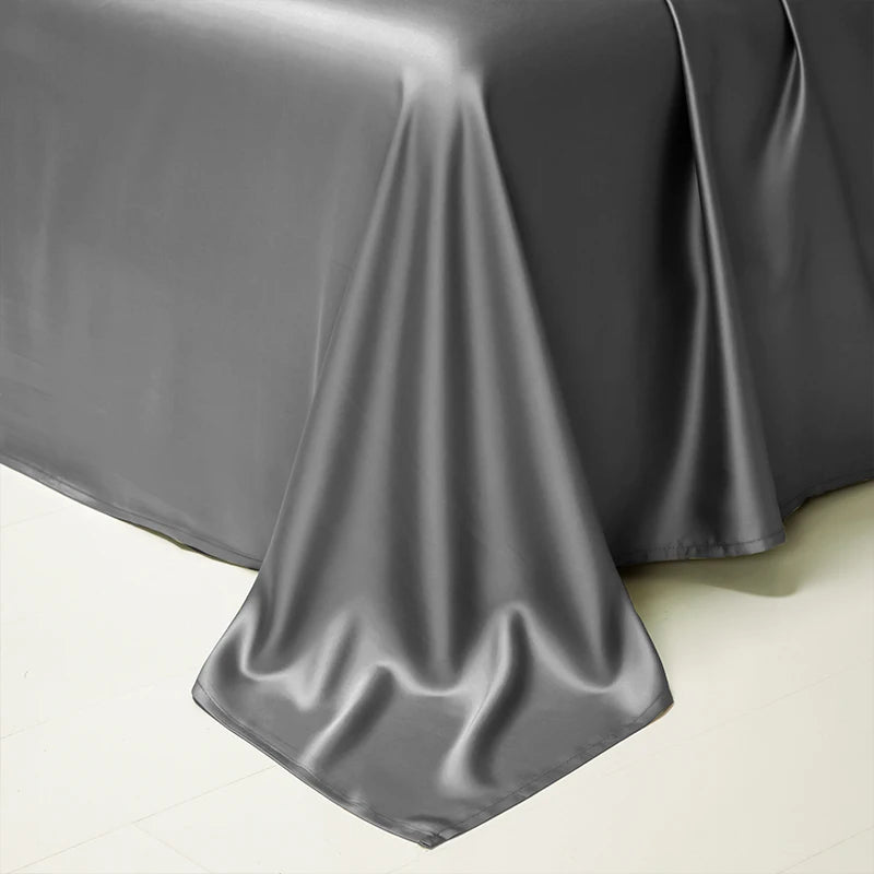 A drape of gray luxury Egyptian cotton bedding fabric folded neatly on a light surface.