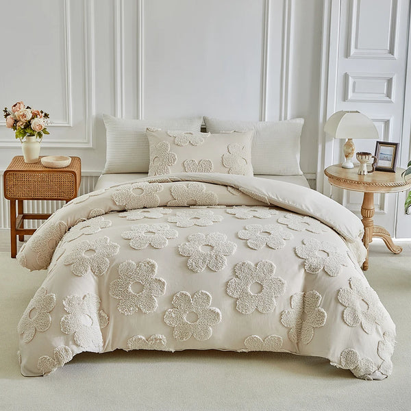 A cream tufted floral duvet cover set with matching pillowcases displayed on a bed in a bright room.