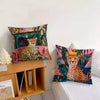 A close-up of a floral and leopard print cushion cover featuring cheetahs and tropical leaves.