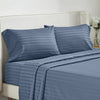 A navy blue striped bedding set featuring a duvet cover, sheet, and pillow on a white upholstered bed.