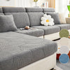 A gray luxury sofa slipcover featuring a textured leaf pattern with white decorative flowers.