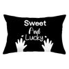 Black pillow cover with white text that reads Sweet And Lucky and features a white hand print