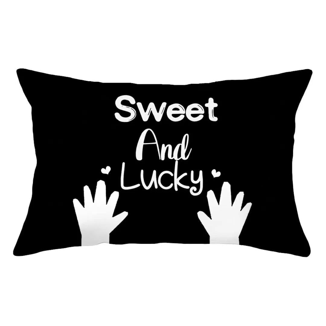 Black pillow cover with white text that reads Sweet And Lucky and features a white hand print